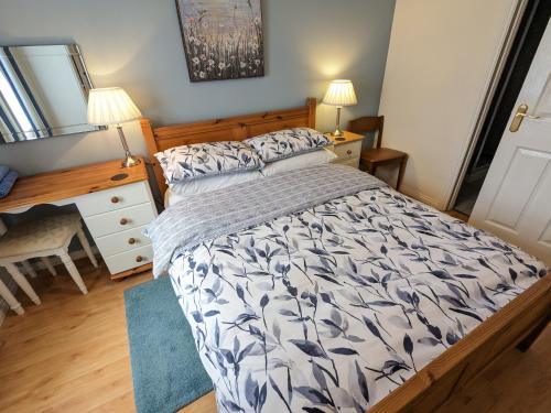a bedroom with a bed and a desk and a mirror at The Jays in Bryansford