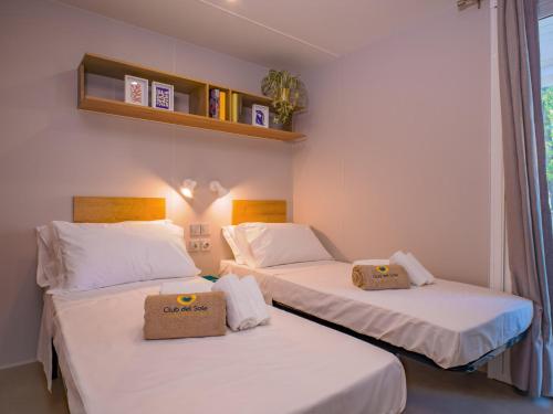 two twin beds in a room with a window at Club del Sole Stork Family Collection in Giulianova