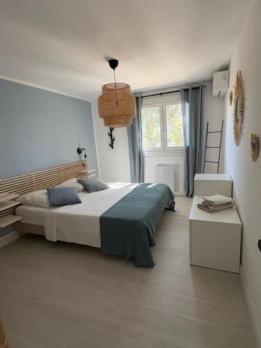 une chambre avec un grand lit et une fenêtre dans l'établissement T2 tout confort et moderne, climatisé avec balcon et parking, à 10 min du port et de la plage, à Sanary-sur-Mer