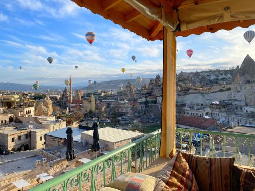 a balcony with hot air balloons flying over a city at Gedik Cave Hotel in Goreme