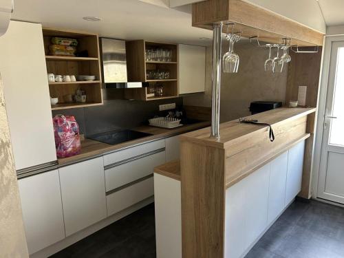 a kitchen with white cabinets and wooden counter tops at MAX Apartmán pri jazere in Trstice