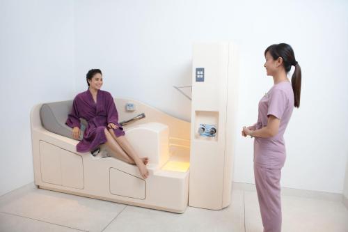 a woman standing next to a patient in a hospital room at Naman Retreat in Da Nang