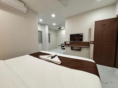 1 dormitorio con 1 cama con albornoz en Hotel Mithra Grand, en Hyderabad