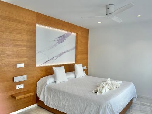 Un dormitorio con una cama con un cuadro en la pared. en SMILE CAVANA APARTMENTS, en Nerja