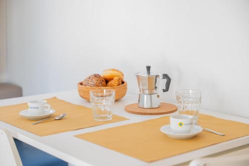 a table with a coffee maker and a basket of bread at Club del Sole Stork Family Collection in Giulianova
