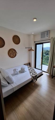a bedroom with a bed and a large window at Escape Boutique Hotel in Puerto Princesa City
