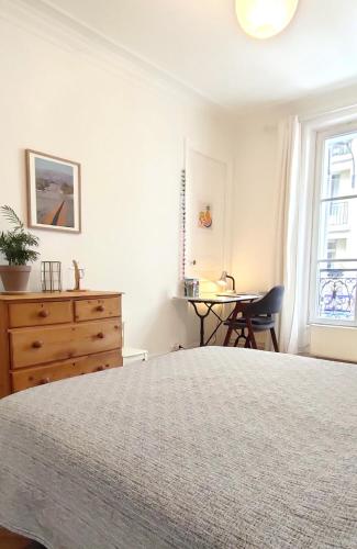 une chambre avec un lit, une commode et une table dans l'établissement Potain - CI - Spacious and cosy duplex for 5 people, à Paris
