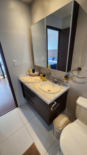 a bathroom with a sink and a toilet and a mirror at The Urban Echo in Cochabamba