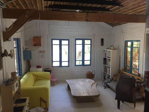 a living room with a yellow couch and a table at The house of Kadita in Kadita