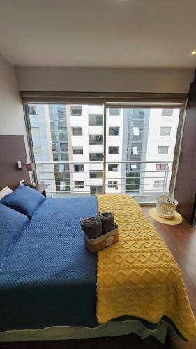 a bedroom with a blue bed and a large window at The Urban Echo in Cochabamba