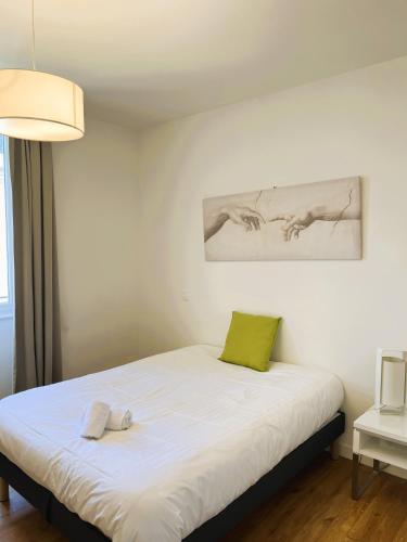 - une chambre avec un lit et un oreiller vert dans l'établissement Résidence de Laval, à Laval