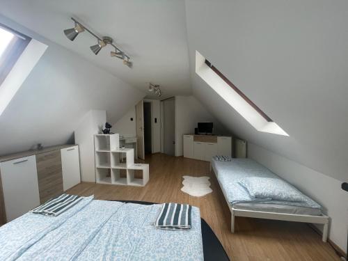 a attic room with two beds and a staircase at Átrium Dunaujváros in Dunaújváros