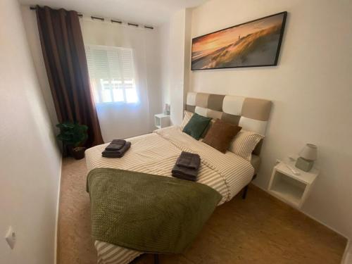 Un dormitorio con una cama con dos toallas encima. en Brisa del mar, en Torrevieja