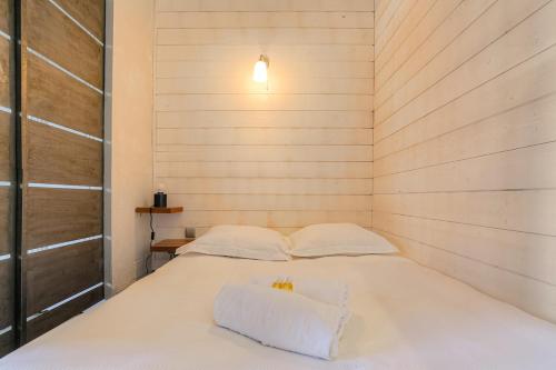- une chambre avec un lit blanc dans un mur en bois dans l'établissement Joli studio fonctionnel, 2 personnes, Charpennes, à Villeurbanne