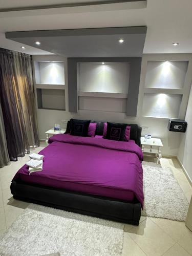 a bedroom with a large bed with purple sheets at Appartement RITZ in Tangier