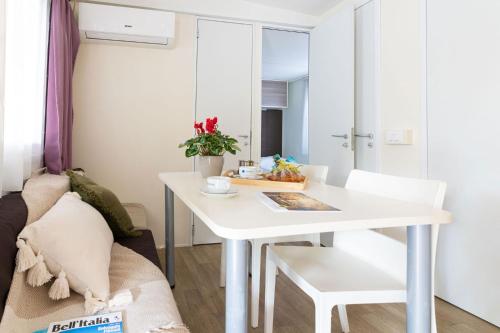 a white table and chair in a small room at Club del Sole Stork Family Collection in Giulianova