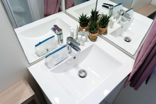 a bathroom with a white sink and a mirror at Club del Sole Stork Family Collection in Giulianova