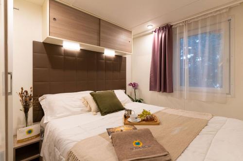 a bedroom with a large bed with a wooden headboard at Club del Sole Stork Family Collection in Giulianova
