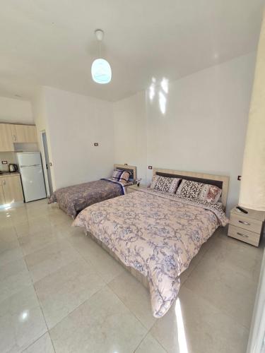 a bedroom with two beds and a kitchen at Summer Tale Rooms in Lezhë