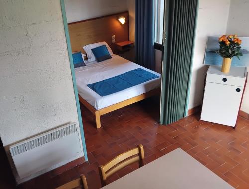 een kleine slaapkamer met een bed en een spiegel bij Canopéa by ULVF in Sainte-Marie-la-Mer