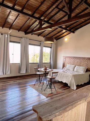 une chambre avec un lit, une table et des chaises dans l'établissement Vista da Serra, à Lavras Novas