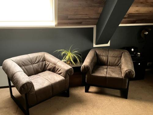 two chairs and a chair in a living room at Hotel Dichtbijzee in Oosterend