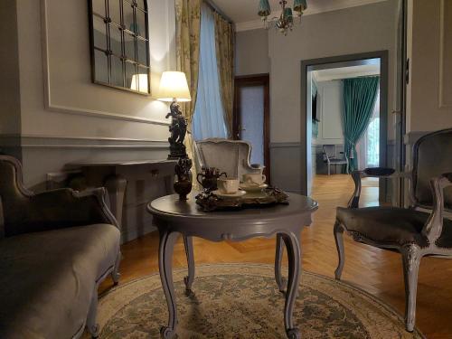 a living room with a table with a lamp and chairs at Casa Timpuri Vechi in Sibiu