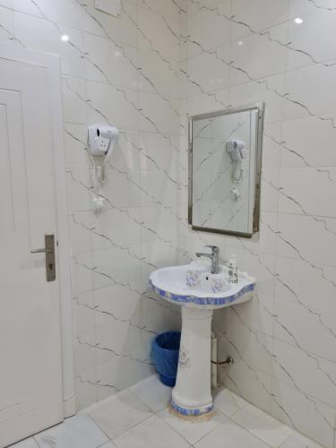 une salle de bain avec un lavabo et un miroir dans l'établissement Wind alula, à Al-Ula