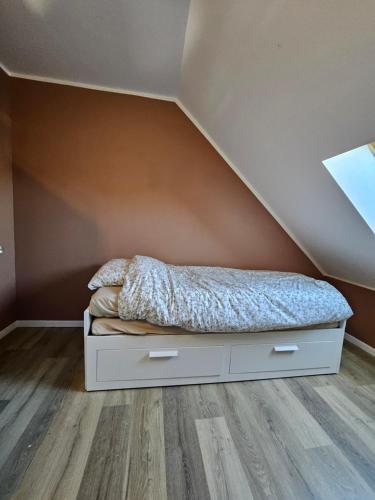 Ce lit se trouve dans une chambre mansardée. dans l'établissement O centre, à Steenvoorde