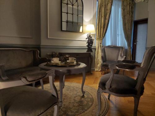a living room with a coffee table and chairs at Casa Timpuri Vechi in Sibiu