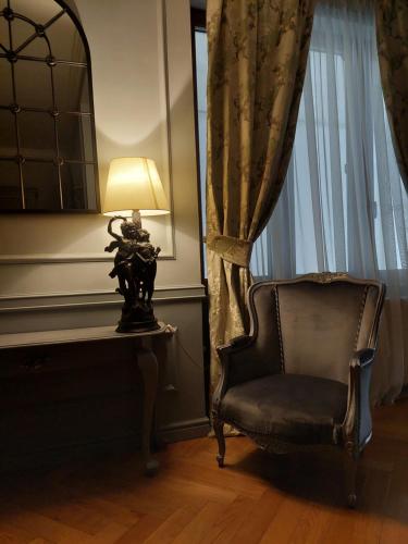 a lamp sitting next to a chair next to a window at Casa Timpuri Vechi in Sibiu