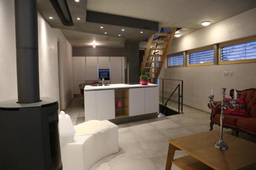 a living room with a kitchen and a living room with a staircase at Le Holzberg et ses Suites in Osenbach