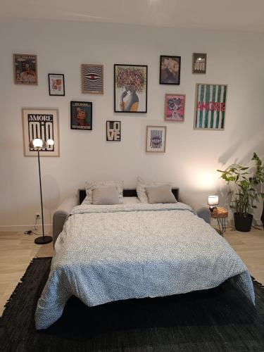 - une chambre avec un grand lit et des photos sur le mur dans l'établissement Le petit fort, à Boulogne-sur-Mer