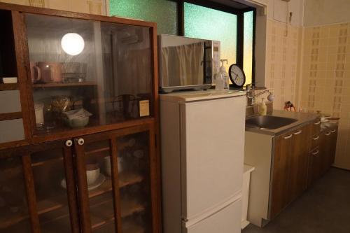 a kitchen with a refrigerator and a sink and a microwave at Poo&Mee in Takemiya