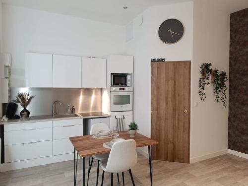 une cuisine avec une table et une horloge au mur dans l'établissement Le petit fort, à Boulogne-sur-Mer