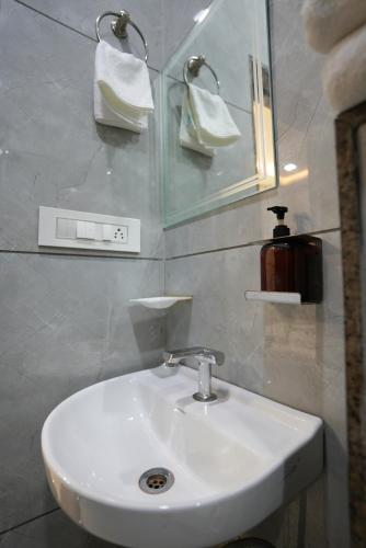 a bathroom with a white sink and a mirror at RRA Retreat Hotel , Best Hotel in Nathdwara Near Shrinathji Mandir in Nāthdwāra