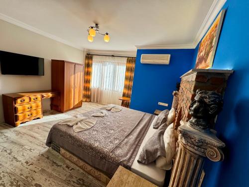 a bedroom with a bed and a blue wall at Rebetika Hotel & bistro in Selcuk