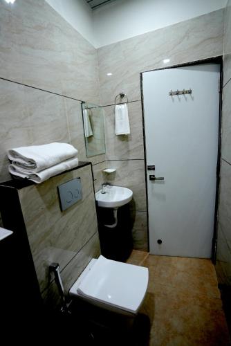 a bathroom with a white toilet and a sink at RRA Retreat Hotel , Best Hotel in Nathdwara Near Shrinathji Mandir in Nāthdwāra
