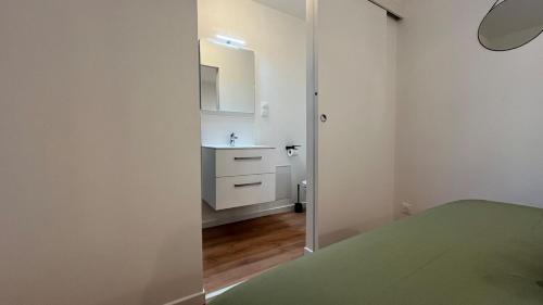 une salle de bain blanche avec un lavabo et un miroir dans l'établissement 22B Studio avec Extérieur Coin Nuit & Cuisine, à La Roche-sur-Yon