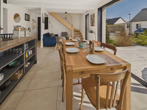 une cuisine et une salle à manger avec une table et des chaises en bois dans l'établissement Maison neuve avec terrasse pour 6 personnes, à Bénodet