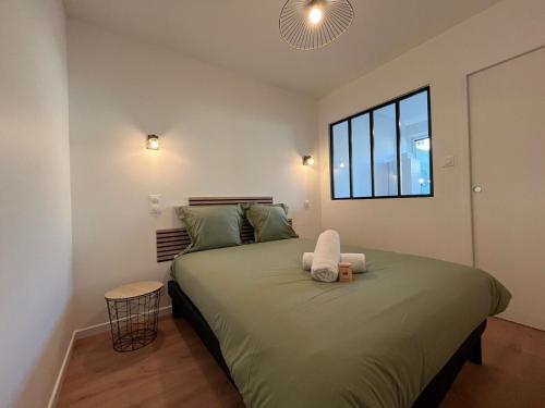 - une chambre avec un grand lit vert et une fenêtre dans l'établissement 22B Studio avec Extérieur Coin Nuit & Cuisine, à La Roche-sur-Yon
