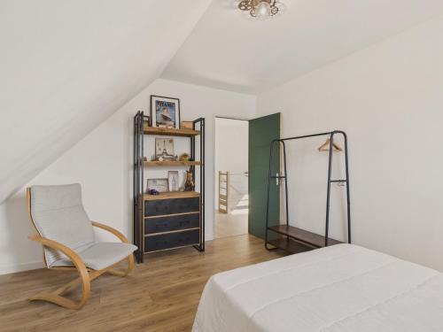 a white bedroom with a bed and a chair at Maison neuve avec terrasse pour 6 personnes in Bénodet