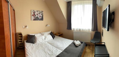 a small bedroom with a bed and a window at Angel's vendégház in Eger