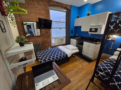a small room with a bedroom with a bed and a desk at Metropolitan Studio Apartments Manhattan in New York