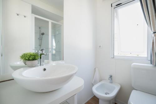 a white bathroom with a sink and a toilet at Club del Sole Stork Family Collection in Giulianova