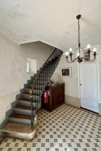 a staircase in a house with a chandelier at Domaine de la Geneste in Châteaufort
