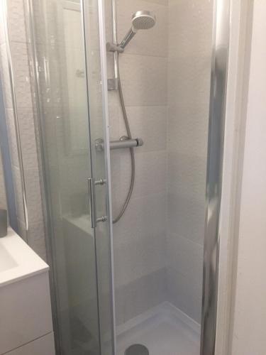 une douche avec une porte vitrée dans une salle de bain dans l'établissement LES GITES CHEROIS agréable RDC maison- 2 personnes, à Les Chères