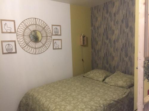 une chambre avec un lit et un miroir au mur dans l'établissement LES GITES CHEROIS agréable RDC maison- 2 personnes, à Les Chères