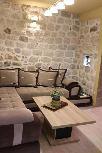 科托尔Piano apartments的客厅里有一张沙发和一张桌子。