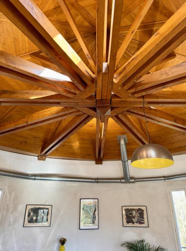 a ceiling with wooden beams and a light fixture at Domaine de la Geneste in Châteaufort